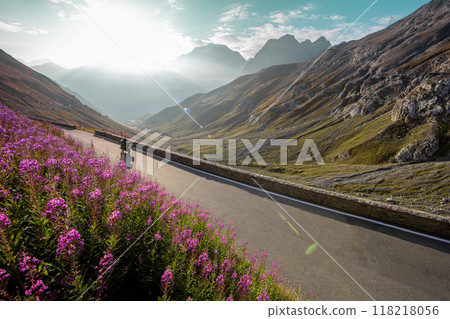 Motorbiker riding in Italian Alps during sunrise, dramatic sky. Travel and freedom, outdoor activities Motorbiker riding in Italian Alps during sunrise, dramatic sky. Travel and freedom, outdoor activities 118218056