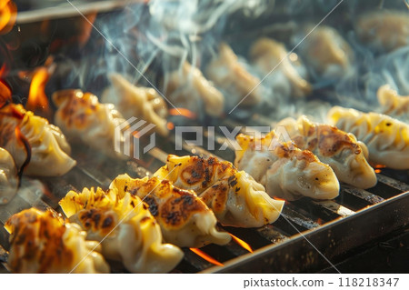 Delicious grilled dumplings sizzling and smoking on a hot barbecue grill Delicious grilled dumplings sizzling and smoking on a hot barbecue grill 118218347