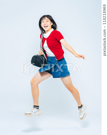 Full body photo of a girl jumping energetically 118218969