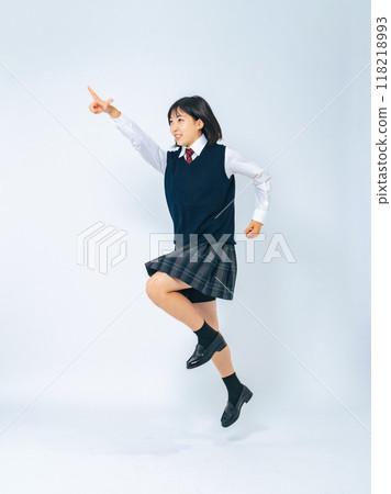Full-body photo of a female student pointing at the sky and jumping towards her goal Full-body photo of a female student pointing at the sky and jumping towards her goal 118218993