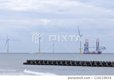 Wind turbines lined up along the coast 118219658