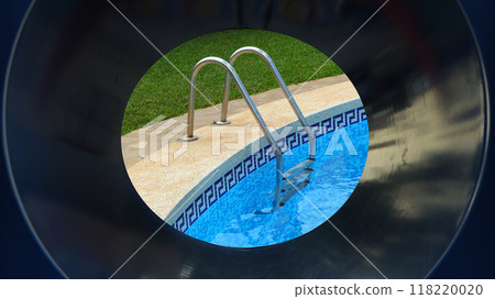 A swimming pool ladder stands beside vibrant blue water, surrounded by lush green grass in a serene backyard. The sunlight reflects off the water's surface, creating a relaxing atmosphere. A swimming pool ladder stands beside vibrant blue water, surrounded by lush green grass in a serene backyard. The sunlight reflects off the water's surface, creating a relaxing atmosphere. 118220020