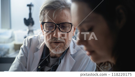Portrait of mature scientist discussing scientific research with female colleague 118220175