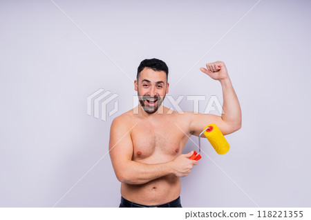 Young employee handyman using paint roller hold face isolated on background studio. Young employee handyman using paint roller hold face isolated on background studio. 118221355
