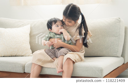 Older sister comforting her younger brother 118221409
