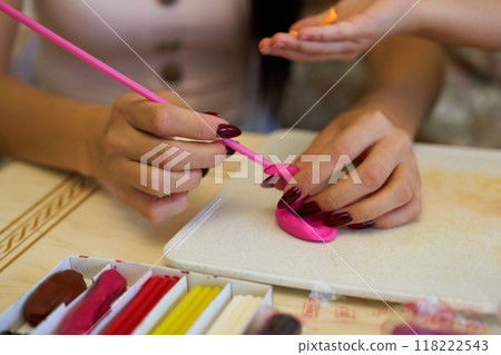 Creating colorful decorations with craft supplies at a table during daytime Creating colorful decorations with craft supplies at a table during daytime 118222543
