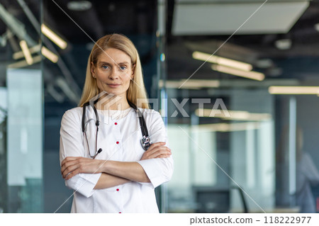 Confident female doctor wearing white lab coat and stethoscope in modern office. Medical professional expressing competence and assurance in healthcare environment. 118222977