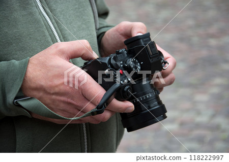 Closeup of hands of photographer with camera looking at the screen in the street Closeup of hands of photographer with camera looking at the screen in the street 118222997