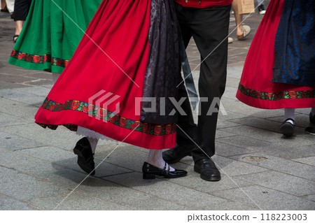 Closeup of legs of traditional alsatian dancers with colorful costume dancing in the street 118223003