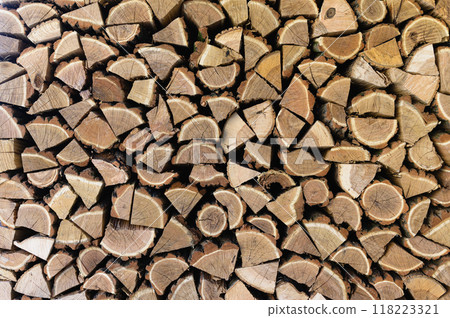 A woodpile with harvesting and stacked firewood of chopped wood. A woodpile with harvesting and stacked firewood of chopped wood. 118223321