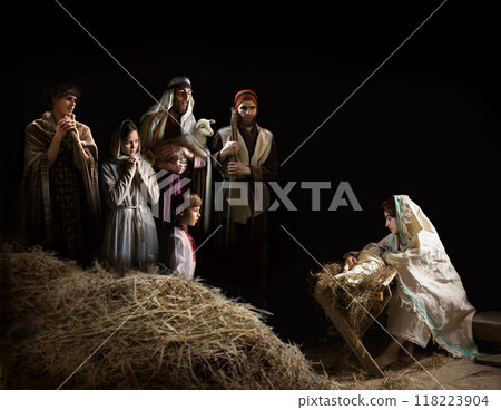 Mary sits in the stable near the manger with the baby 118223904