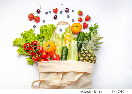 Grocery shopping. Different fresh fruit and vegetables in a textile shopper bag on white background, healthy food from supermarket or delivery concept. 118224054