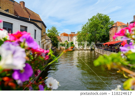 Beautiful Scenic View of a Picturesque Canal in Bruges, Belgium with Colorful Flowers 118224617