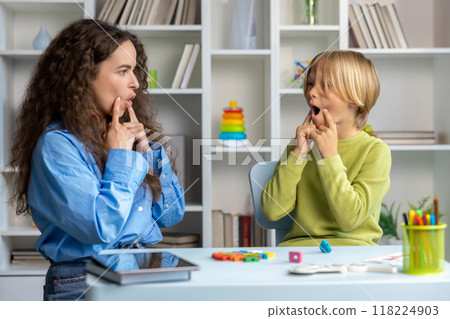 Blonde boy exercising with speech therapist and making efforts 118224903
