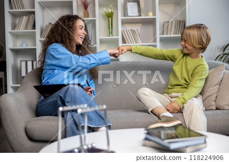 Long-haired young woman talking to a blonde boy, both looking contented Long-haired young woman talking to a blonde boy, both looking contented 118224906