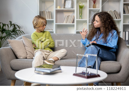 Blonde boy talking to a speech therapist before the beginning of session 118224911