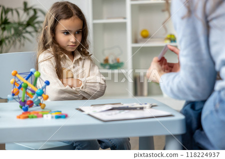 Long-haired cute girl sitting in a closed pose and feeling upset Long-haired cute girl sitting in a closed pose and feeling upset 118224937