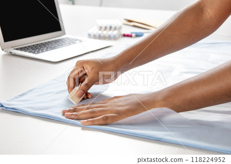 Dressmaker and stylist sewing stylish blue dress or shirt in a professional studio Dressmaker and stylist sewing stylish blue dress or shirt in a professional studio 118224952