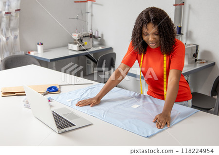 Fashion designer applies chalk to craft new clothing in her modern workshop 118224954