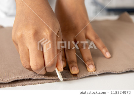 Dressmaker working on clothing projects using material in a professional studio Dressmaker working on clothing projects using material in a professional studio 118224973