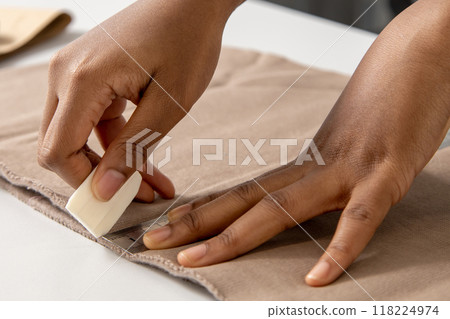 Woman fashion designer applies chalk to sew new clothing in her modern workshop Woman fashion designer applies chalk to sew new clothing in her modern workshop 118224974