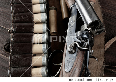 double barreled side shotgun with cartridges in bandolier. 118225046