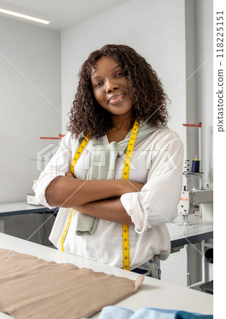 Woman designer and tailor working online on laptop on clothing projects in workshop Woman designer and tailor working online on laptop on clothing projects in workshop 118225151