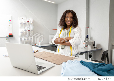 Seamstress engaging in handmade sewing and online fashion design at professional atelier Seamstress engaging in handmade sewing and online fashion design at professional atelier 118225152