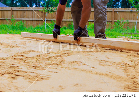Leveling sand when preparing platform before newly installing swimming pool in back yard Leveling sand when preparing platform before newly installing swimming pool in back yard 118225171