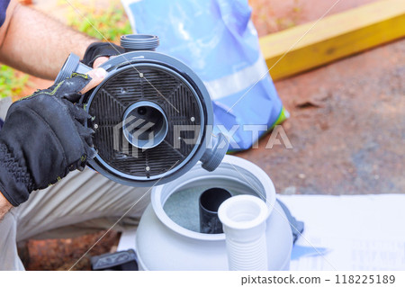 Maintenance worker assembles tank for sand filter system as well as equipment for cleaning water in swimming pool 118225189