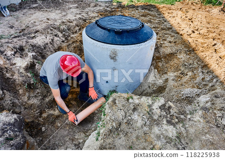 Connecting septic tank to external disposal system, installing out-flowing pipe through which wastewater will flow into leach field. 118225938