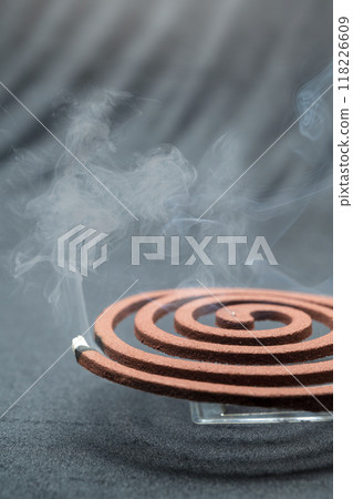 A mosquito coil with smoke coming out of it A mosquito coil with smoke coming out of it 118226609