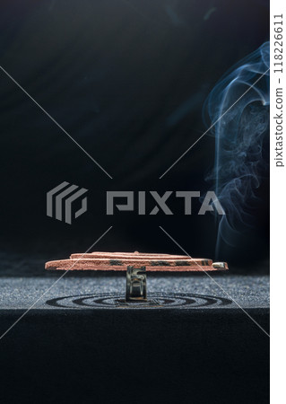 A mosquito coil with smoke coming out of it 118226611