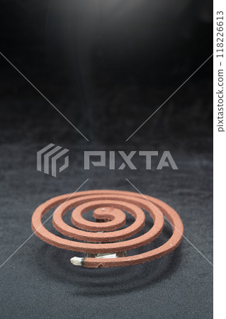 A mosquito coil with smoke coming out of it 118226613