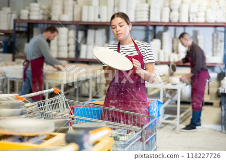 Young woman posing with ceramic dishes Young woman posing with ceramic dishes 118227726