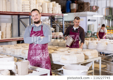 Successful ceramicist standing in pottery slip casting workshop 118227745