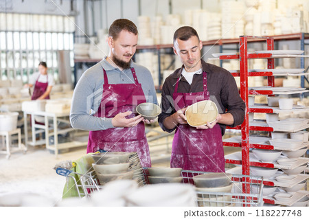 Two potters discussing handcrafted ceramic wares in studio 118227748