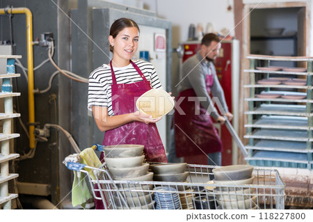 Young woman posing with ceramic dishes Young woman posing with ceramic dishes 118227800