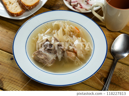 Fragrant cabbage soup with pork rib. Dish is complemented with plate of bacon and bread. 118227813