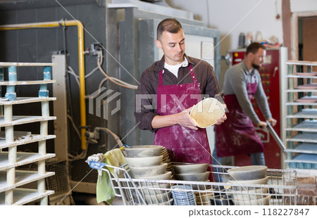 Young man posing with ceramic dishes Young man posing with ceramic dishes 118227847