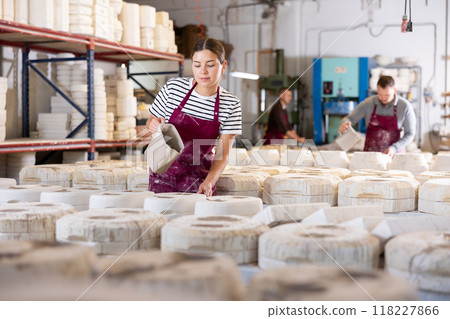 Young woman pouring clay into mold Young woman pouring clay into mold 118227866