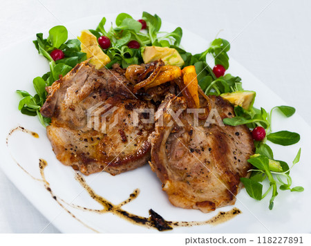 Cooked fried pork meat chops with with greens, avocado and berries Cooked fried pork meat chops with with greens, avocado and berries 118227891