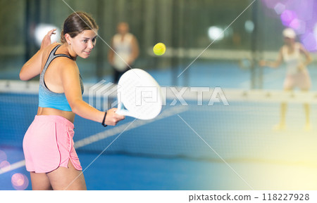 Portrait of girl paddle tennis player during friendly doubles couple match at court 118227928