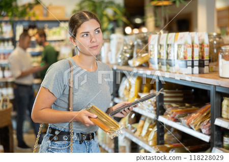 Young girl purchaser buying pasta in grocery store 118228029