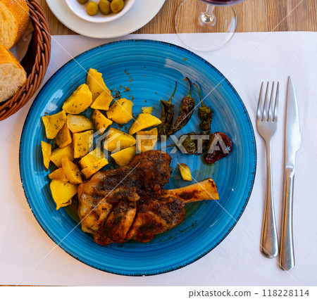 Roasted pork knuckle served with vegetable side dish of potatoes 118228114