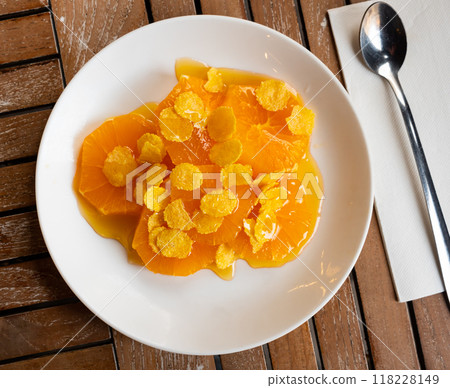 Healthy breakfast, lunch or snack on plate. Orange slices with honey and sprinkled with corn flakes 118228149