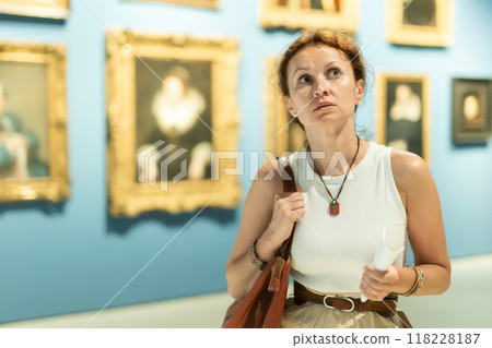 Woman viewing art gallery with brochure 118228187