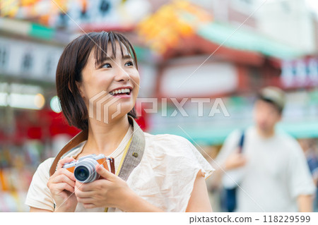 A woman traveling in Asakusa A woman taking pictures at a tourist spot 118229599