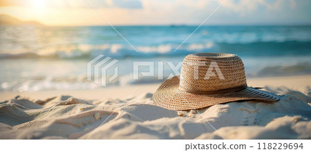 Summer straw hat on beach sand near the sea. Vacation, leisure, Sunbathing and relaxing concept 118229694