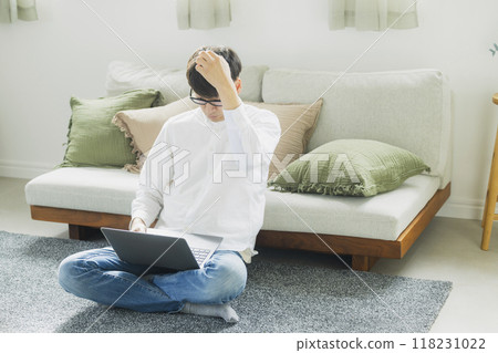 一個人在客廳裡使用個人電腦 一個人在客廳裡使用個人電腦 118231022